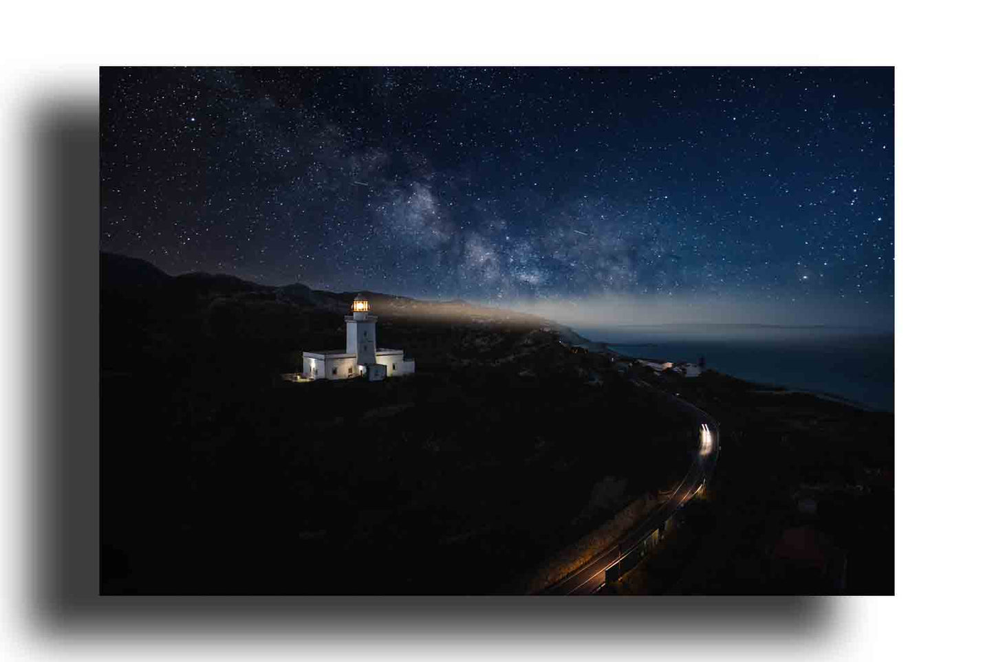 Luz en la Oscuridad: Faro Bajo un Cielo Estrellado